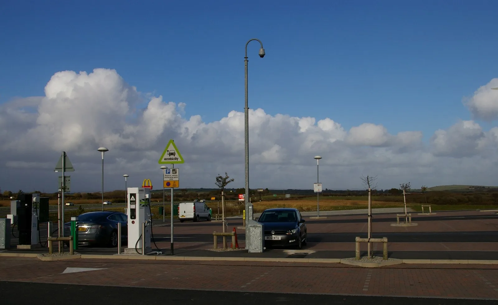 Electric car charging points, Cornwall Services by Christopher Hilton, CC BY-SA 2.0, via Wikimedia Commons